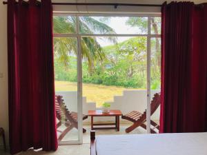 a room with a large window with chairs and a table at Sakalya Lake View in Tissamaharama