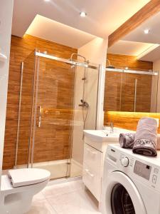 a bathroom with a washing machine and a shower at Downtown Apartments Monroe in Rzeszów