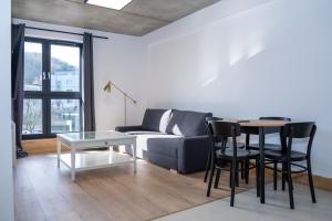 a living room with a couch and a table at Apartamenty Przystanek Morska in Gdynia