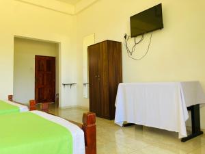 a bedroom with a table and a tv on the wall at Sakalya Lake View in Tissamaharama