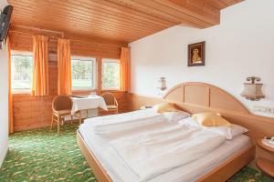 a bedroom with a large bed and a table at Hotel Lichtenstern in Soprabolzano