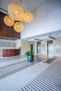 a lobby with a potted plant in the middle of a building at Alashrafia Saray 2BR apartment in Sport City in Dubai