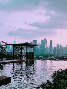 un bâtiment sur l'eau avec une ville en arrière-plan dans l'établissement Kuala Lumpur Datum Jelatek - KLCC view - Infont LRT And 5 Minutes to KLCC -Near by Gleneagles, à Kuala Lumpur