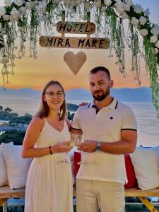 a man and a woman holding wine glasses under a marquee at Hotel Ajden by Mira Mare in Ksamil