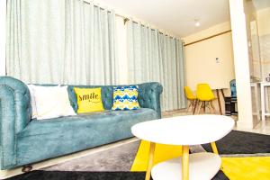 Una sala de estar con un sofá azul y una mesa. en Mt.Kenya View apartment, en Nanyuki 1 foto más