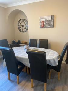 ein Esstisch mit Stühlen und einer Uhr an der Wand in der Unterkunft Sea Haven Northumberland in Seahouses + 31 Fotos