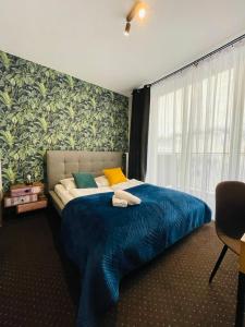 a bedroom with a bed with a blue blanket and a window at Boogie Deluxe Old Town in Wrocław