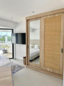 a bedroom with a bed and a sliding glass door at Studio H GrandBay Sea-View in Grand-Baie