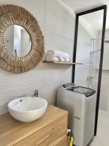 a bathroom with a sink and a toilet and a mirror at Studio H GrandBay Sea-View in Grand-Baie