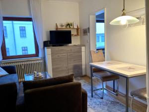 a living room with a couch and a table with a television at Duene 43 in Wangerooge