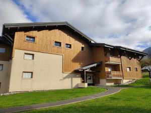 a large brick building with a gambrel roof at studio Morillon village in Morillon