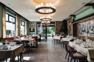 a dining room with tables and chairs and a chandelier at Landhaus Klosterwald in Lich