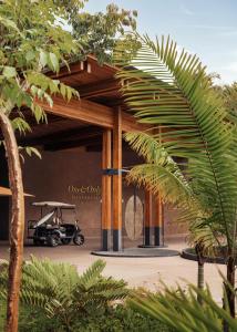 a golf cart parked under a building with trees at One&Only Mandarina in Lo de Marcos