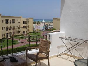 een stoel op een balkon met uitzicht op de oceaan bij Amwaj Oyoun hotel Nabq Bay in Sharm El Sheikh