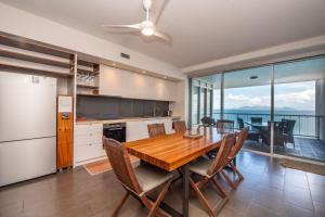 a kitchen and dining room with a table and chairs at 1 Bright Point Apartment 5404 in Nelly Bay