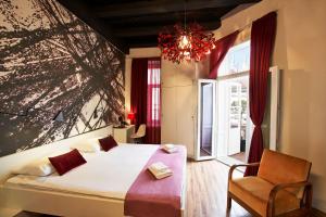 a bedroom with a bed and a chair and a window at Art Hotel Like in Zagreb