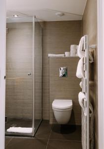 La salle de bains est pourvue d'une douche, de toilettes et de serviettes. dans l'établissement ClapClap Hôtel, Food & Bar, à Strasbourg