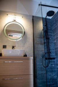 La salle de bains est pourvue d'un lavabo et d'une douche avec un miroir. dans l'établissement Mike's studio, à Vólos