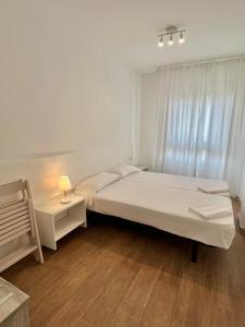 - une chambre avec un lit et une lampe sur une table dans l'établissement Apartamentos Centro Benicasim, à Benicàssim