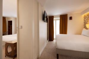 a hotel room with two beds and a window at Hotel Michelet Odeon in Paris