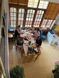 un grupo de personas sentadas en una mesa comiendo comida en Alex Hostel, en Ha Long