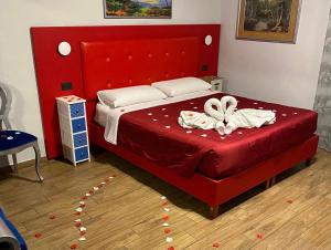 a bedroom with a red bed with a red head board at B&B Magada in Messina