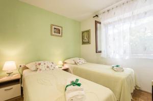 two twin beds in a room with a window at House Vinka in Selca