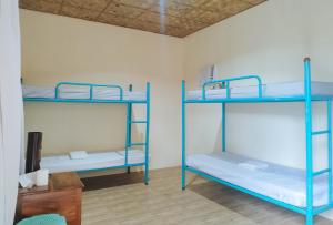 Zimmer mit 3 Etagenbetten und einem Schreibtisch in der Unterkunft Casa Nena Hotel & Resort Iloilo by RedDoorz in Iloilo City