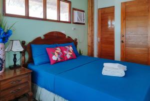 1 dormitorio con cama azul y cabecero de madera en Casa Nena Hotel & Resort Iloilo by RedDoorz en Iloílo