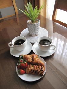 a table with two cups of coffee and a plate of food at Scarborough, South Cliff Seaside Garden Apt in Scarborough