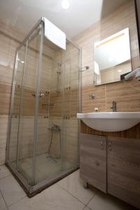 een badkamer met een glazen douche en een wastafel bij Comfort Hotel Taksim in Istanbul
