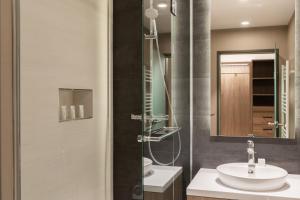 La salle de bains est pourvue d'un lavabo et d'une douche. dans l'établissement AC Hotel by Marriott Berlin Humboldthain Park, à Berlin