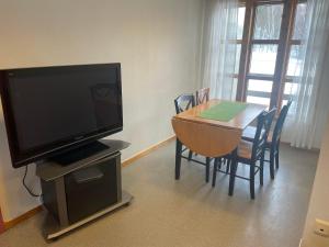 - un salon avec une télévision et une table avec des chaises dans l'établissement Nye Heimen Overnatting, à Namsos
