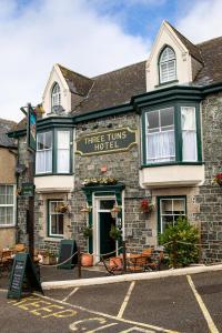 un edificio de piedra con un hotel atrue Times en una calle en Three Tuns, en Helston