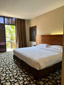 um quarto com uma cama grande e uma janela grande em Malibest Resort em Pantai Cenang