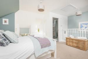 Habitación blanca con cama y balcón. en Stoney Creek Cottage - Cosy Cottage in the heart of Crail, en Crail