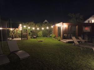 a backyard at night with chairs and lights at Villa Cork in Dębki