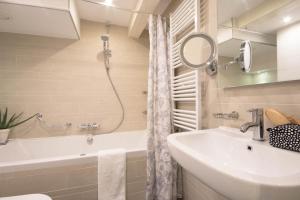 a bathroom with a sink and a tub and a mirror at Amsterdam Canal Suites in Amsterdam +75 photos