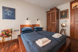 een slaapkamer met een groot bed met blauwe lakens en handdoeken bij Le Rendezvous Apartments New Town in Veliko Tŭrnovo