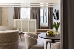 a living room with chairs and a table with a bowl of fruit at Amsterdam Canal Suites in Amsterdam