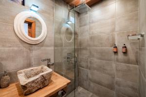 a bathroom with a shower with a sink and a mirror at Le Rendezvous Apartments New Town in Veliko Tŭrnovo