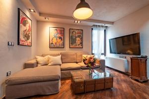 een woonkamer met een bank en een flatscreen-tv bij Le Rendezvous Apartments New Town in Veliko Tŭrnovo