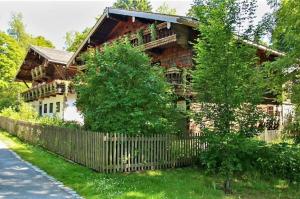 una casa de madera con una valla delante en Parkside Appartement, en Grafenau