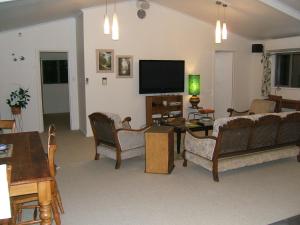 a living room with couches and a flat screen tv at Memory Lane Country Cottage in Cambridge