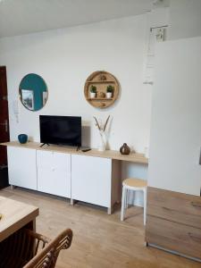 een woonkamer met een bureau en een tv. bij Escale à Épernay: Studio proche du centre ville in Épernay