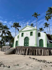 塔曼達雷的住宿－ECO RESORT PRAIA DOS CARNEIROS - NOVÍSSIMO，海滩上的白色教堂,种植了棕榈树