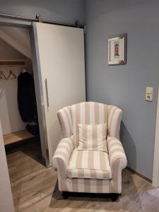 a white chair in a room with a closet at Burghaus 1 in Greetsiel