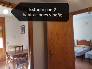 una camera con una porta, un tavolo e un letto di Alojamiento Rural Sierra de Gudar a Valbona
