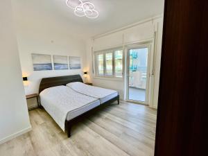 um quarto com uma cama e uma grande janela em Condominio Martini em Grado