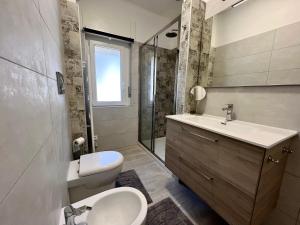 a bathroom with a sink and a toilet and a shower at Condominio Martini in Grado